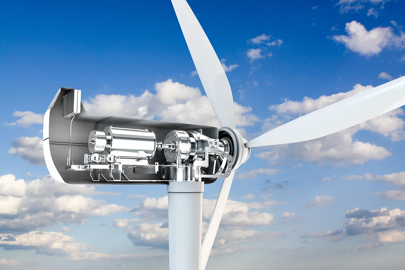 A close-up view of a wind turbine with part of its nacelle casing cut away, revealing the internal machinery, set against a blue sky with scattered white clouds.
