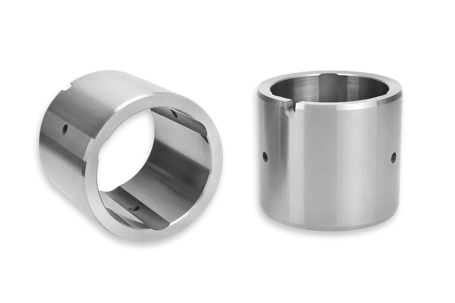 Two cylindrical metal machine parts with smooth, shiny surfaces and multiple holes, each shown from a different angle to display the interior and exterior features.
