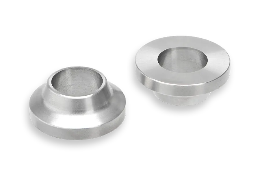 Two machined metal components with a cylindrical base and a wide, flat top, featuring a central circular opening, placed on a plain background.