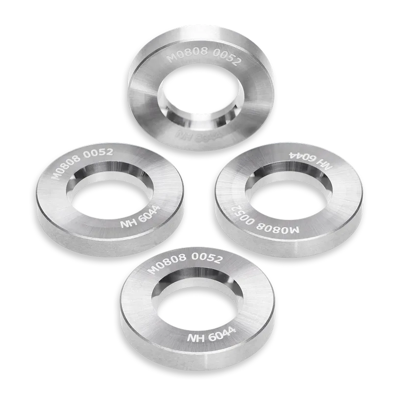 Four metallic circular components with a central hole, each engraved with M0808 0052 NH 6044, arranged on a white background.