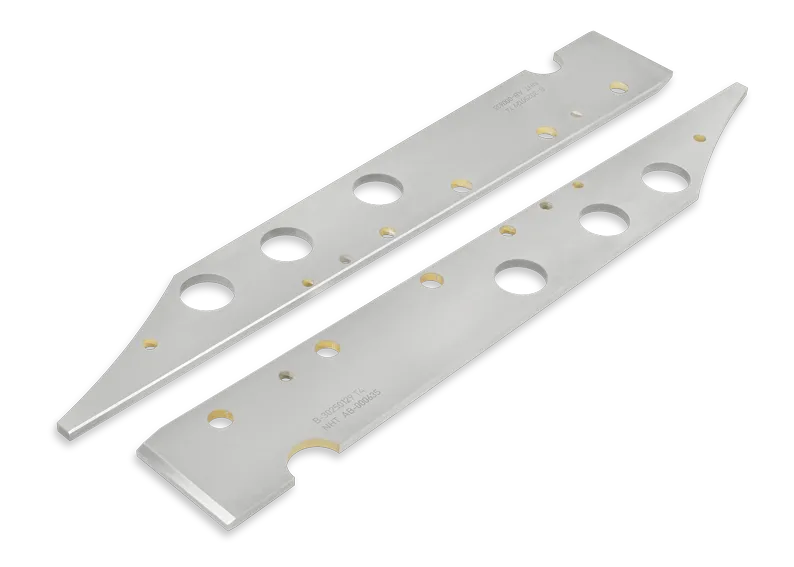 Two elongated, silver metal plates with multiple circular holes and beveled edges, placed parallel to each other on a white background. Small engraved text and gold accents are visible on each plate.