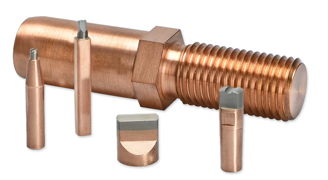 Five components with tungsten-copper (WCu) inserts: a threaded bolt with a hexagon, two slender pins, a half-round piece and a short cylinder.